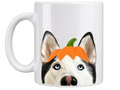 A white ceramic coffee mug featuring a printed illustration of a husky dog's face with a small orange pumpkin on its head, set against a plain white background.